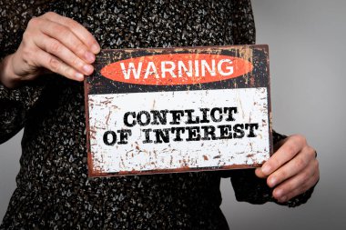 Çıkar çatışması kavramı. Metin ile uyarı işareti.