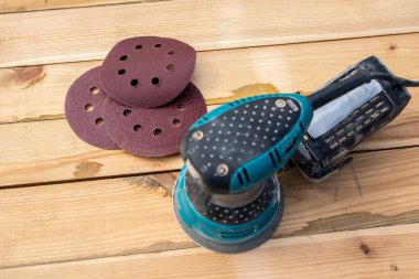 Yuvarlak zımpara kağıdı diskleri ve çim biçme makinesi. Ahşap arkaplan.