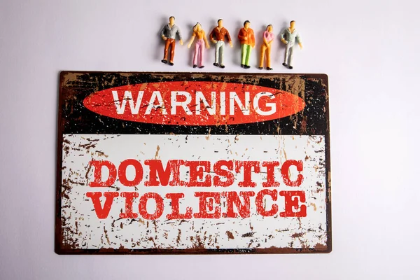 家庭暴力 白色背景上带有文字和微型人物形象的示警标志 — 图库照片
