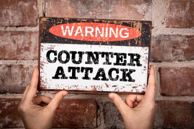Karşı atak. Kırmızı tuğla zemin üzerinde metin olan uyarı işareti.