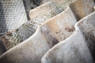 Eski bir çatı kaplaması yığını. Asbest, insanlara ve çevreye zararlı. Doku.