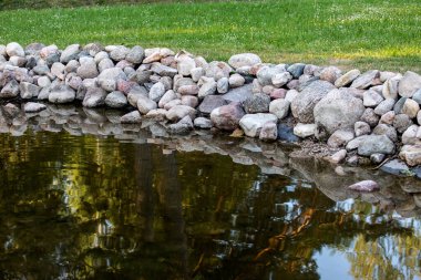 Kayalarla güçlendirilmiş bir kıyı şeridi. Erozyon ve peyzaj.