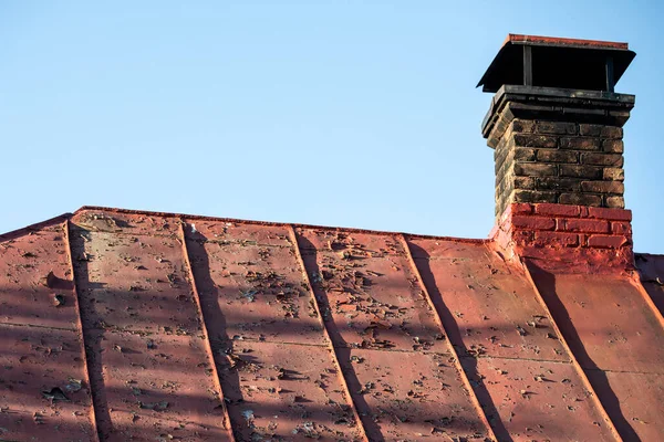 旧的油漆金属屋顶 剥皮的油漆和旧的砖制烟囱 — 图库照片