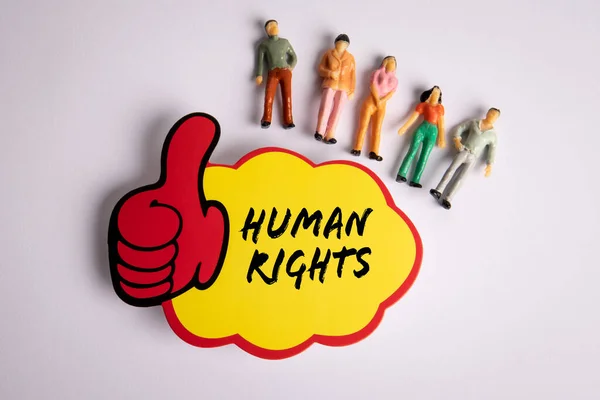 stock image Human Rights. Sticky note with text and miniature human figures on a white background.