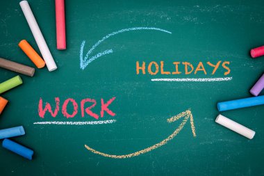 Tatil Günleri Konsepti. Yeşil bir karatahtanın üzerinde renkli tebeşir ve metin parçaları.