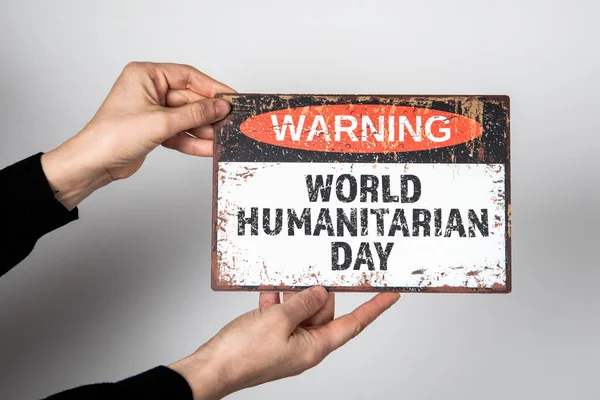 World Humanitarian Day 19 August. Warning sign with text on a white background.