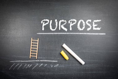 PURPOSE Konsepti. Minyatür merdivenler ve siyah bir karatahta yazı..