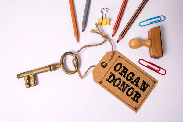 ORGAN DONOR. Cardboard price tag and key on a white background.