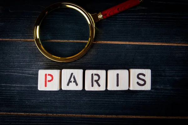 PARIS. Word from alphabet blocks on a dark textured background.