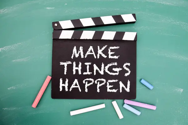 Make things happen. Motivational reminder text on a chalk board film clapper.