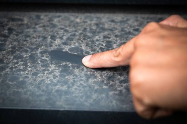 Tozlu yüzey, parmaklarıyla kayıyor. Kentsel kirlilik.