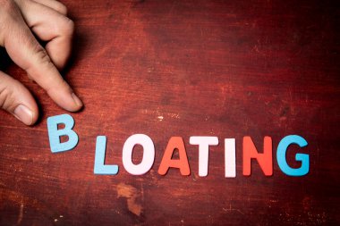 Boğuluyor. Ahşap doku arkaplanındaki renkli alfabe harflerinden kelime.