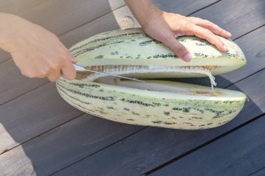 Kavunu bıçakla ikiye bölmek. Yaz meyveleri.