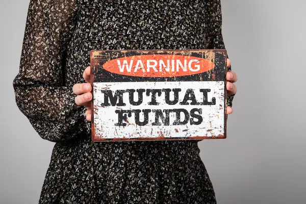 Mutual Funds. A warning sign in a womans hands.