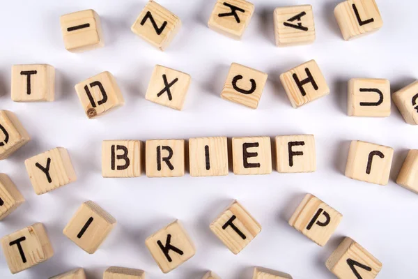 BRIEF. Wooden alphabet letter blocks on a white background.