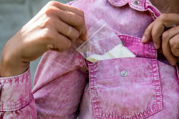 Cebimden bir torba beyaz toz çıkıyor. Bağımlılık ve yasadışı ticaret kavramı.