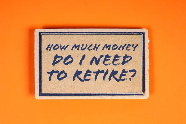 stock image How much money do I need to retire. Cardboard sticky note on an orange background.