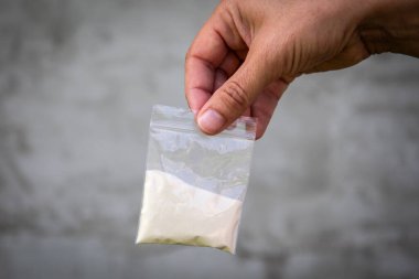 Elinde bir torba beyaz toz. Yasak maddeler için görüntü, bağımlılık kavramı.
