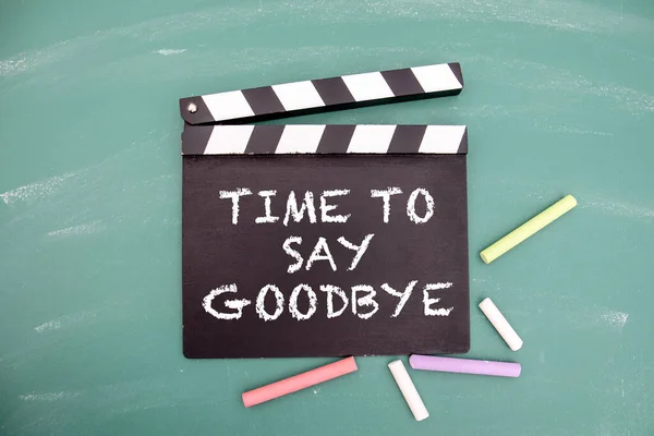Time to say goodbye. Movie clapper and colored pieces of chalk.