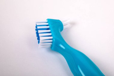 Beyaz arka planda takma diş fırçası. Diş ve diş etlerinin etkili temizliği.
