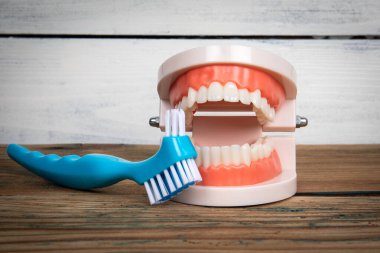 Tahta arka planda diş fırçası ve diş izleri var. Diş fırçalama ve sağlık konsepti.