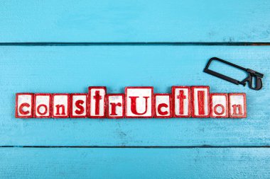 Mavi ahşap arka planda minyatür bir testere var. İnşaat ve marangozluk konsepti.