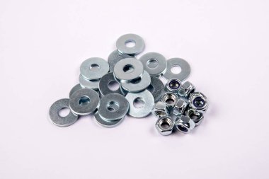 Düz çamaşır makinesi ve çinko kaplama altıgen fındıklar beyaz arka planda.