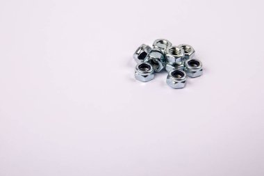 Beyaz arkaplanda çinko kaplamalı altıgen fındıklar, metin için yer.