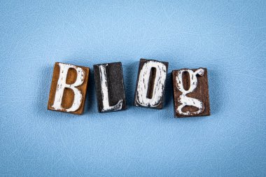 BLOG. Mavi desenli arkaplanda tahta alfabe harf blokları.