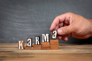 KARMA. Tahta harfler, basamaklarda alfabe blokları. Geliştirme ve büyüme kavramı.