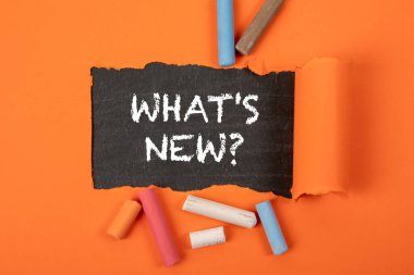 Ne var ne yok? Tahtada yırtık turuncu kağıdın altında metin.