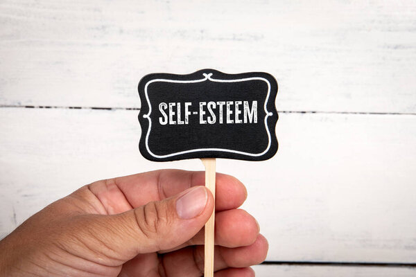 Self-esteem. Miniature blackboard with text on a white background.