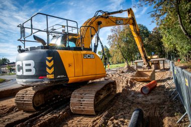 Sigulda, Letonya - 6 Ekim 2024 JCB. Bir kazıcı yol yapılandırması sırasında zemini kazıyor