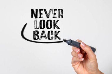 Asla arkana bakma. El ele tutuşan siyah kalem ve beyaz arkaplanda yazı.