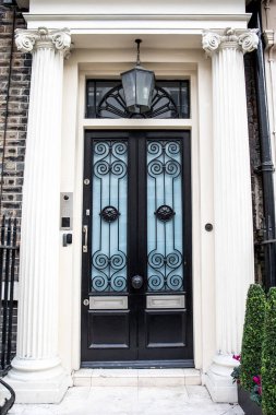 Cam ve metal elementlerle süslü giriş kapısı..