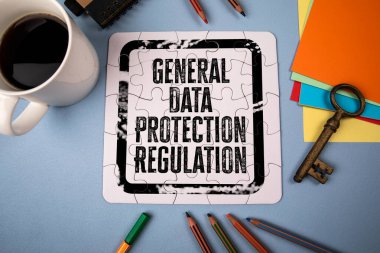 Genel Data Koruma Yönetmeliği. Masada beyaz bulmaca ve ofis malzemeleri.