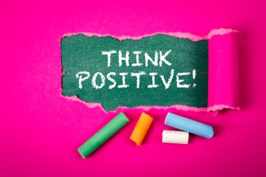 Pozitif düşün. Yeşil karatahta yırtık mor kağıt altında metin.