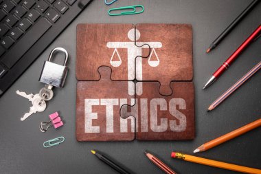 ETHICS kavramı. Karanlık bir ofis masasında yazılı tahta yapboz parçaları..