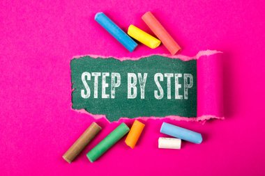 Adım adım. Yeşil karatahta yırtık mor kağıt altında metin.