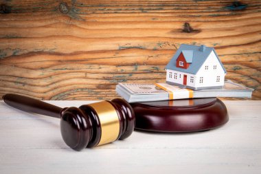 Hukuk ve Yönetmelik Konsepti. Hakimler tokmak, para ve minyatür ev ahşap dokuda..