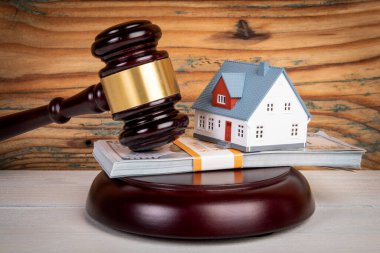 Boşanma anlaşmazlığı ve anlaşma konsepti. Hakimler tokmak, para ve minyatür ev ahşap dokuda..