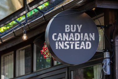 Kanadalıyı satın almak için. Evin duvarında yuvarlak, siyah bir tabela var..