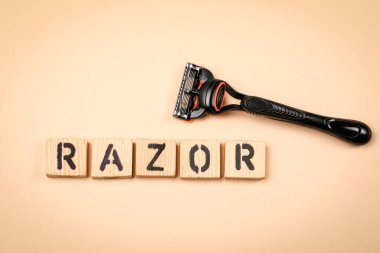 Hafif arkaplandaki tahta alfabe harflerinden yapılmış RAZOR Metni.