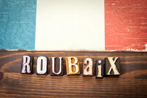 ROUBAIX. Ahşap doku arka planında bayrak ve alfabe harfleri.