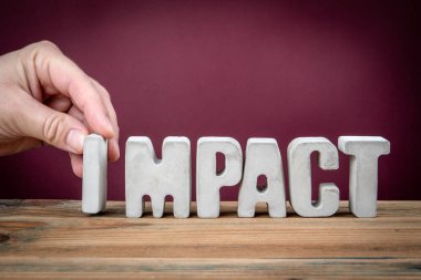 Tahta Masadaki Beton Alfabe Harflerinden yaratılan IMPACT Kelimesi.