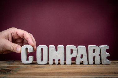 COMPARE Kelimesi Tahta Masadaki Beton Alfabe Harflerinden Oluşturuldu.