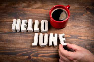 Merhaba June. Somut alfabe harfleri ve koyu ahşap arkaplanda kahve fincanı..
