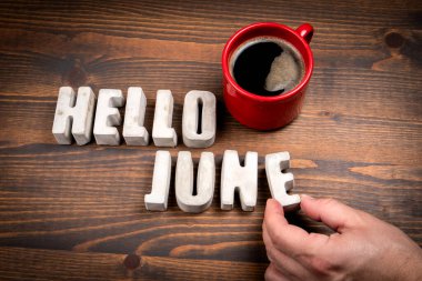 Merhaba June. Somut alfabe harfleri ve koyu ahşap arkaplanda kahve fincanı..