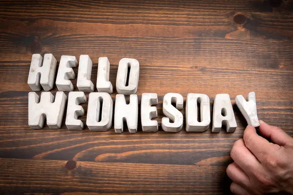 Merhaba Çarşamba. Somut alfabe harfleri ve koyu ahşap arkaplanda kahve fincanı..