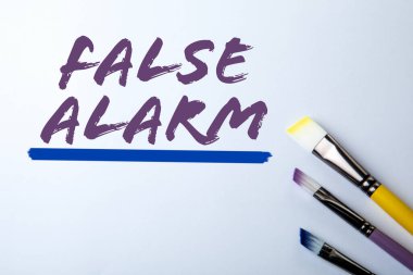 Yanlış Alarm. Beyaz Arkaplan Kavramsal Mesajında Boya Fırçaları ile Metin.